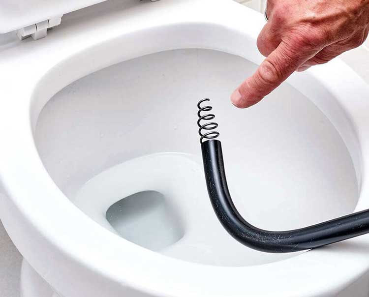 Dùng dây lò xo hoặc dụng cụ thông bồn cầu chuyên dụng
